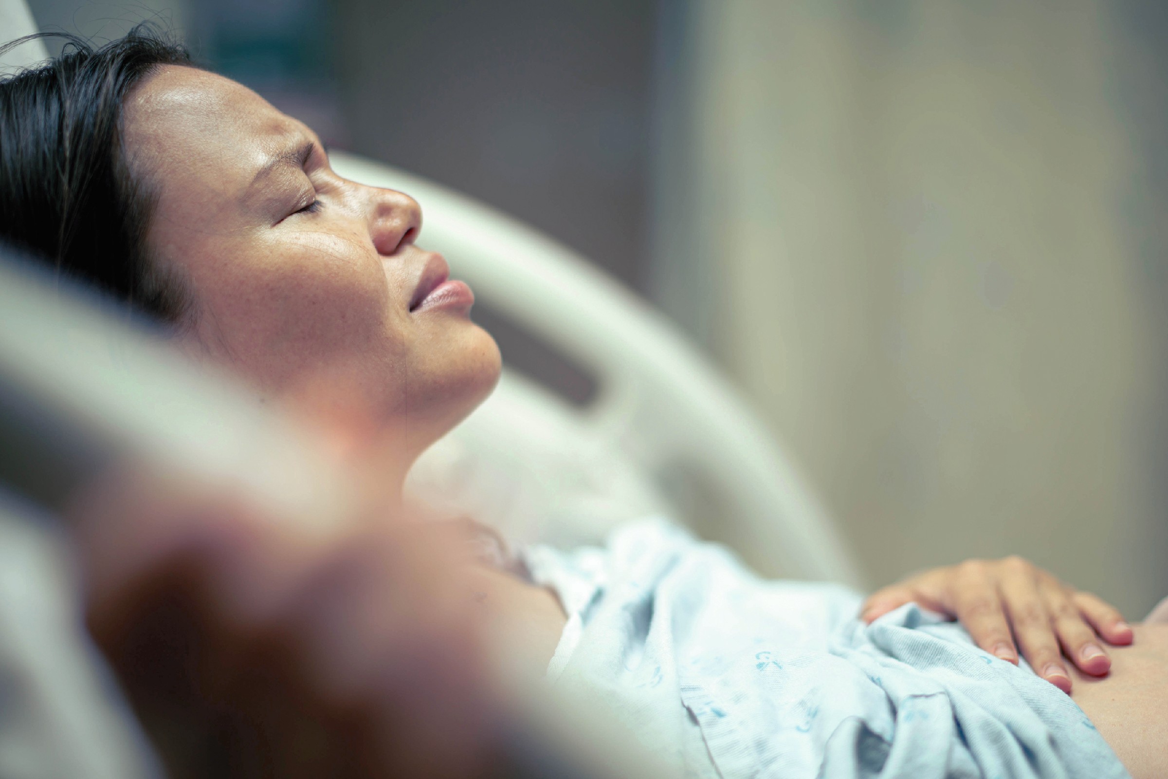A sick woman patient in bed at the hospital suffering from pain. Contractions and childbirth. A sick woman patient in bed at the hospital suffering from pain. Contractions and childbirth.